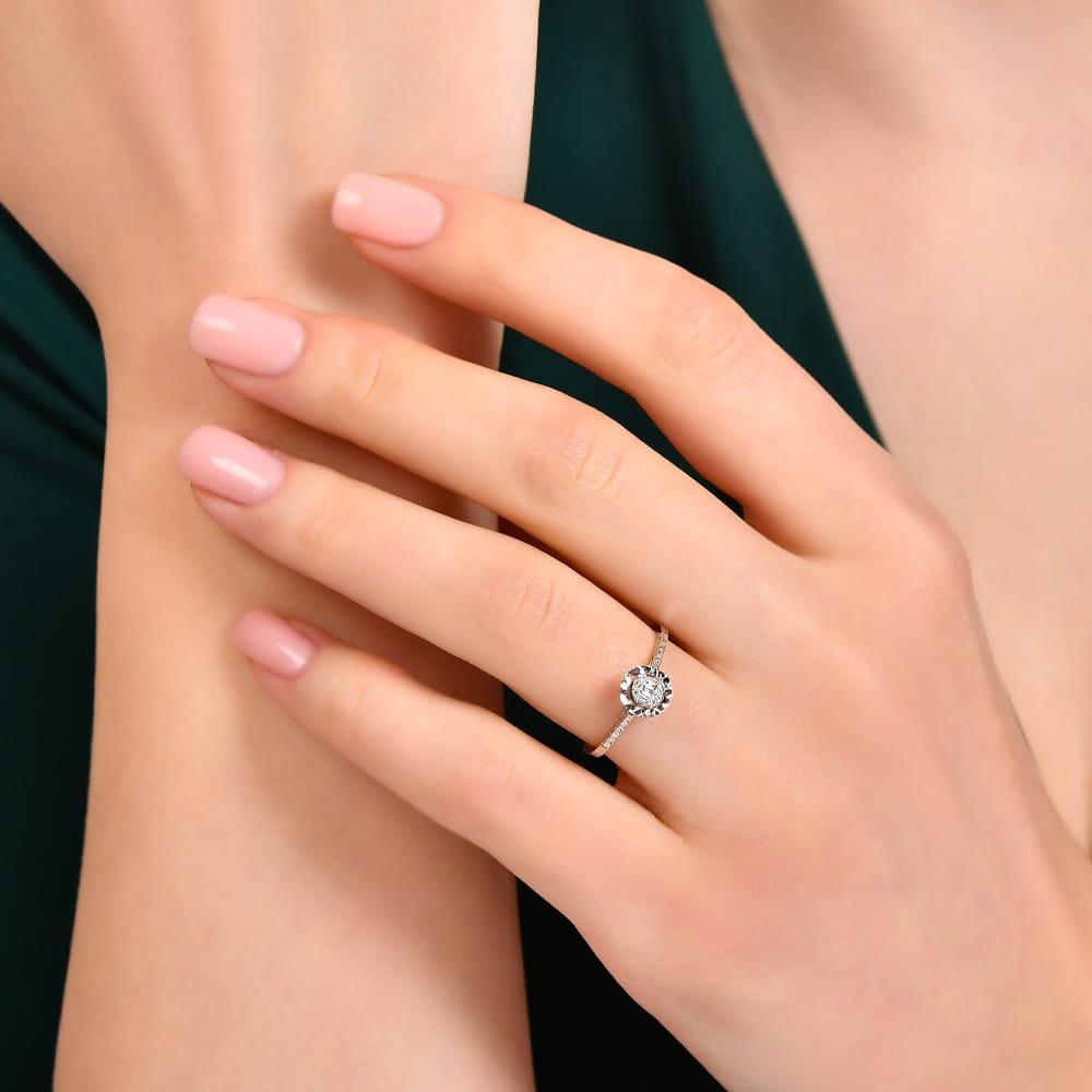 Elegant diamond engagement ring with halo setting on woman's hand