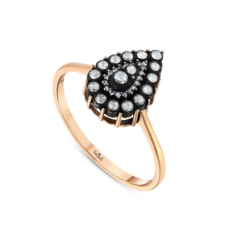 Rose gold ring with pear-shaped diamond cluster and pavé setting on white background